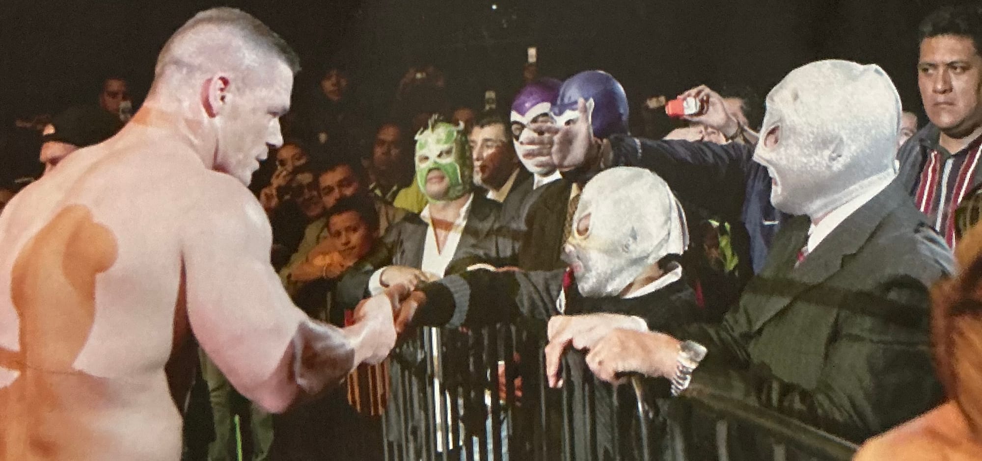 John Cena daps up Santito’s son during a house show in Mexico while Santito looks on.